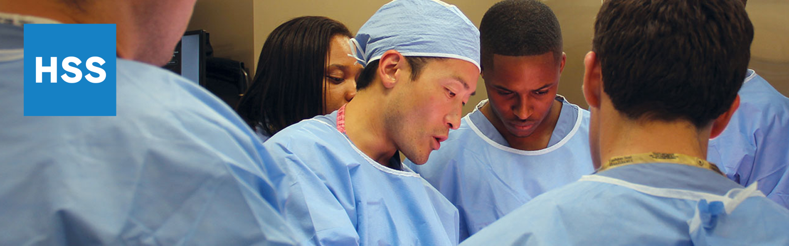 Alumni Banner- students surrounding physician giving instruction